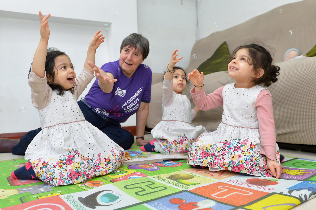 Volunteer-playing-with-triplet-girls-on-floor