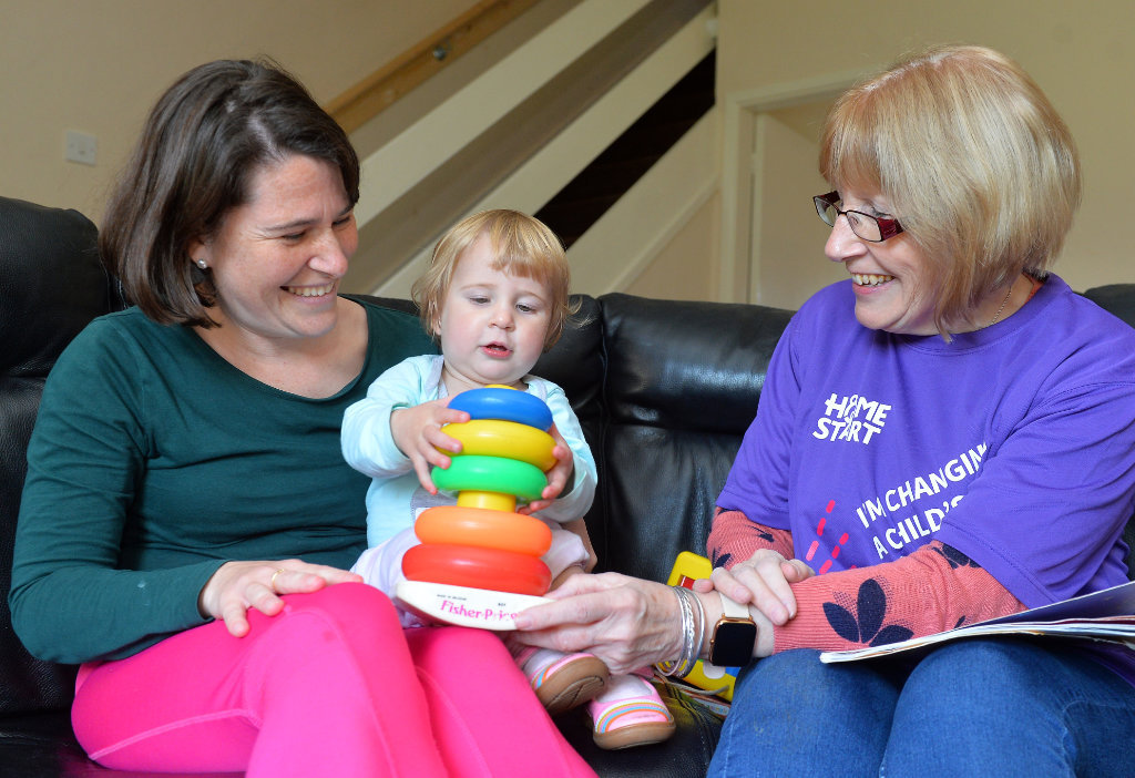 Volunteer-with-mum-and-daughter-on-sofa